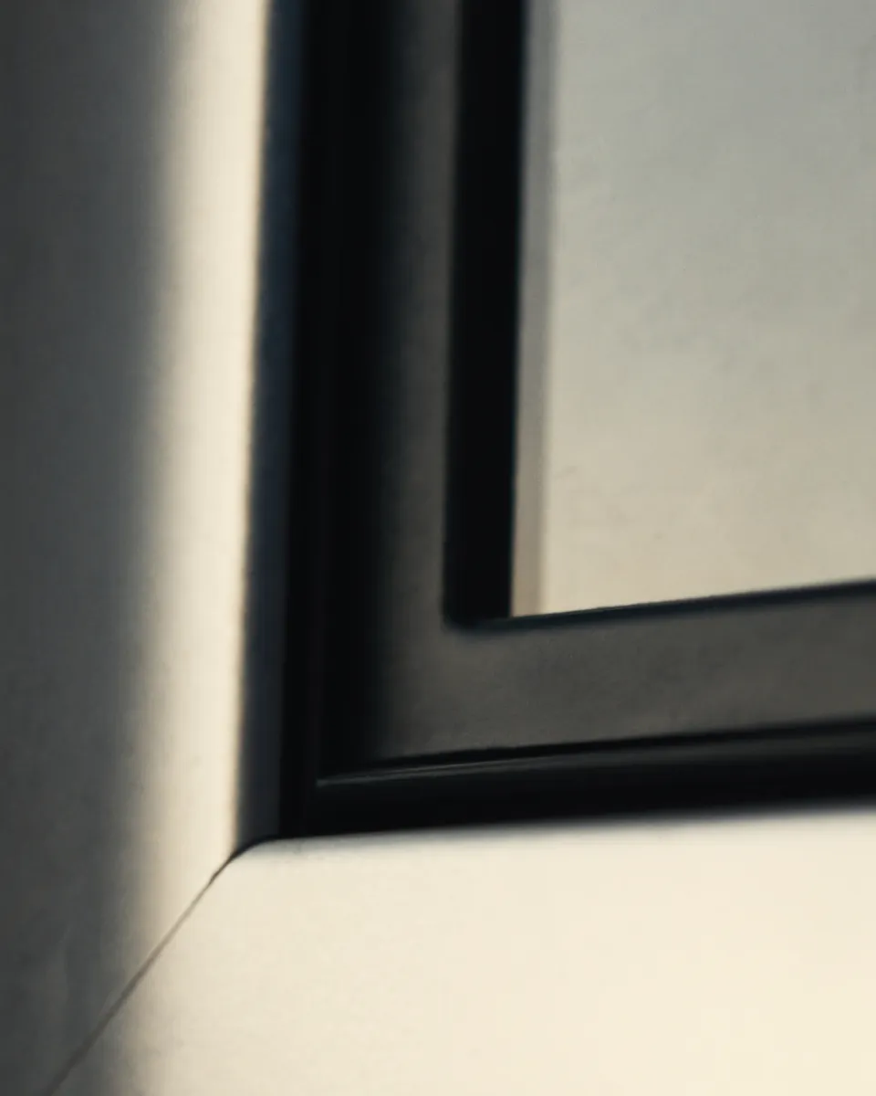 Corner of an anthracite aluminium window frame with its rubber gasket.